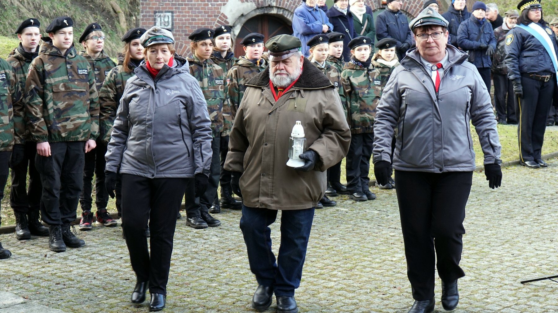 Na zdjęciu harcerze składający znicze