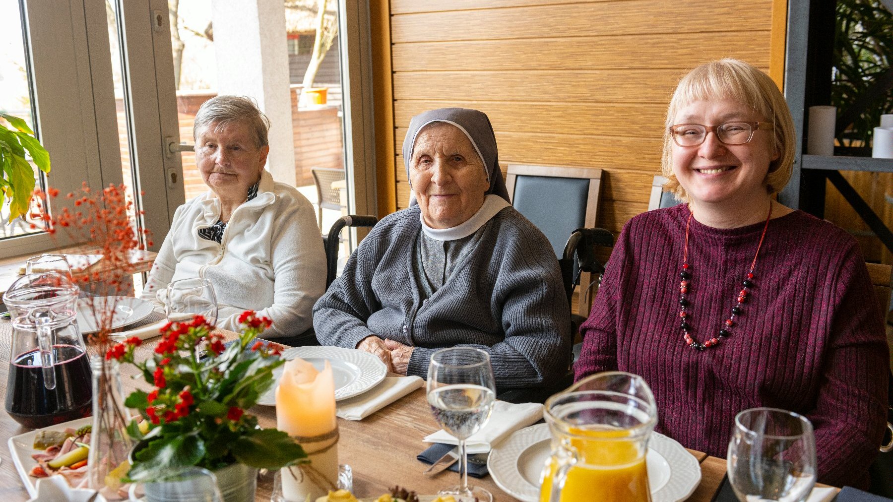 Na zdjęciu trzy uśmiechnięte seniorki, w tym zakonnica