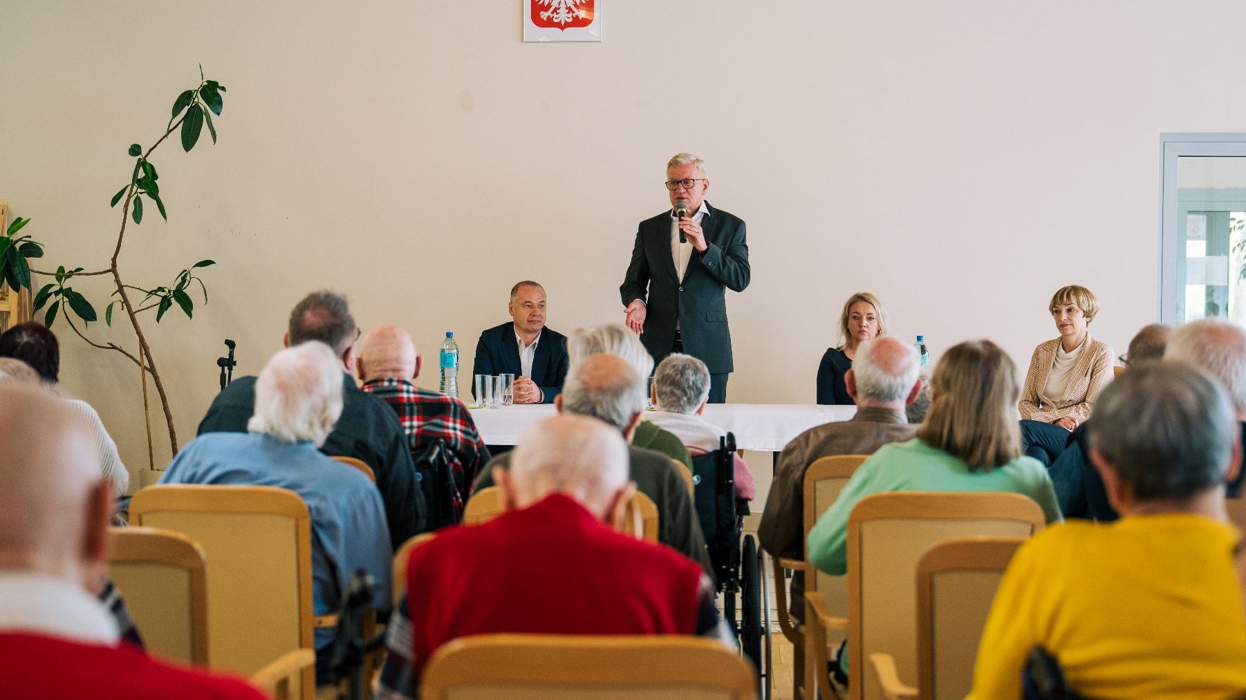 Na zdjęciu prezydent Poznania z mikrofonem w ręku, widać seniorów