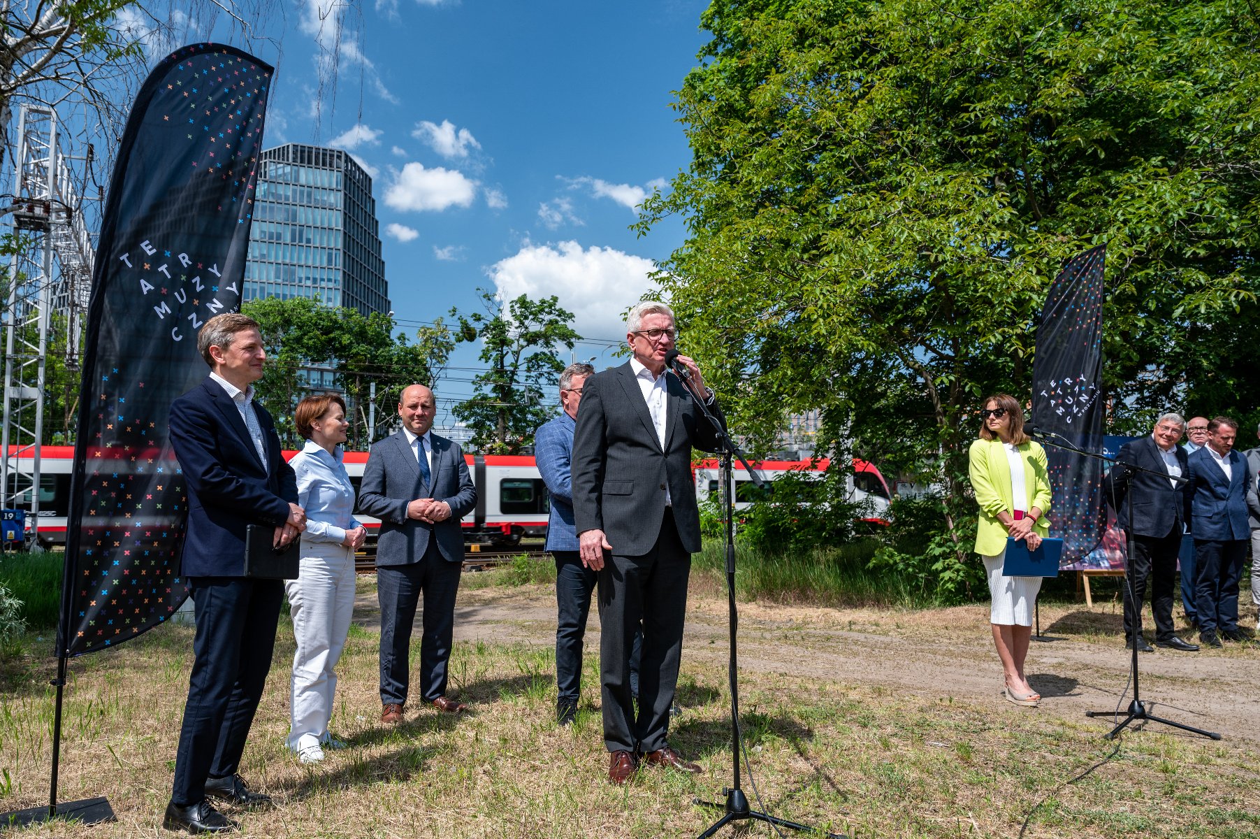 Zdjęcie przedstawia grupę osób podczas konferencji prasowej. W tle biurowiec "Bałtyk". - grafika artykułu