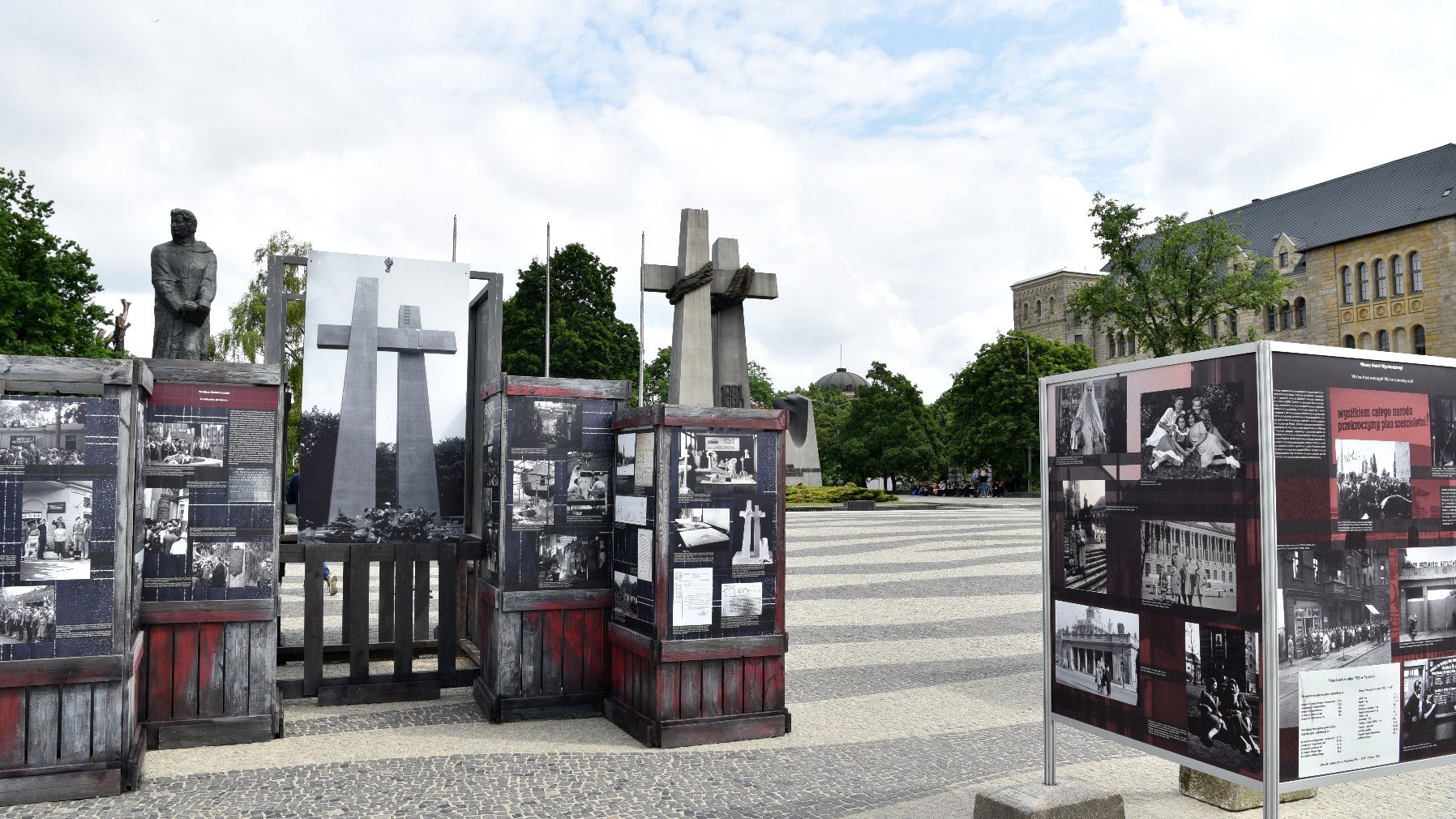 Na pierwszym planie wystawa, w tle pomnik Dwóch Krzyży na placu Mickiewicza