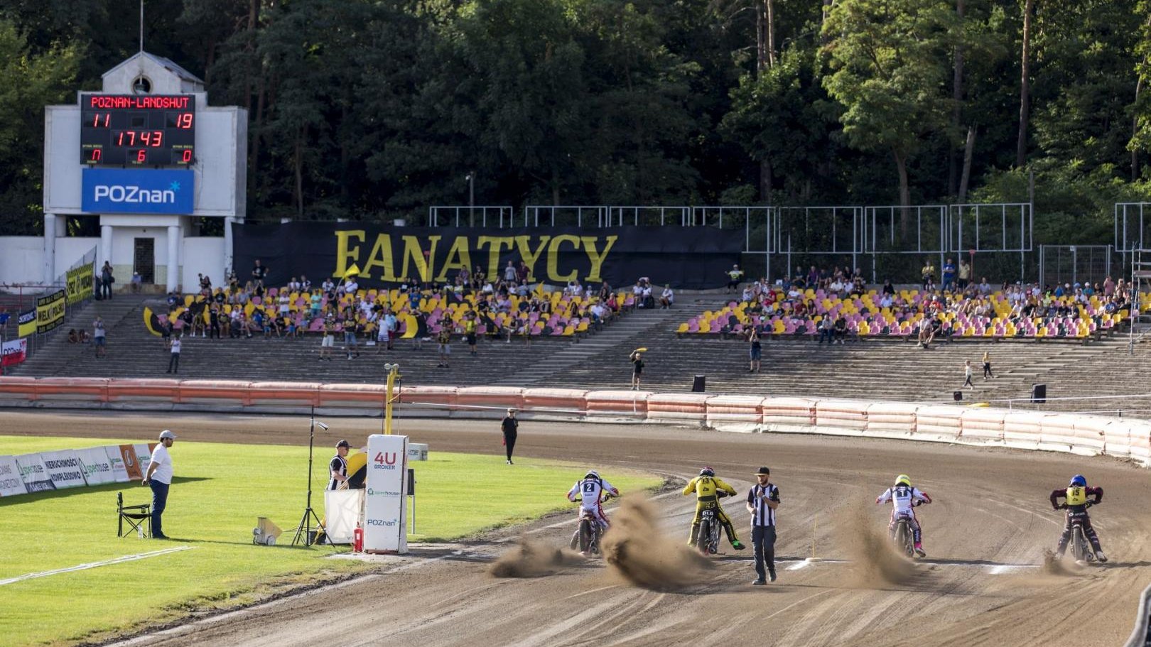 Na zdjęciu widać stadion żużlowy na Golęcinie, startujących żużlowców i kibiców na trybunach