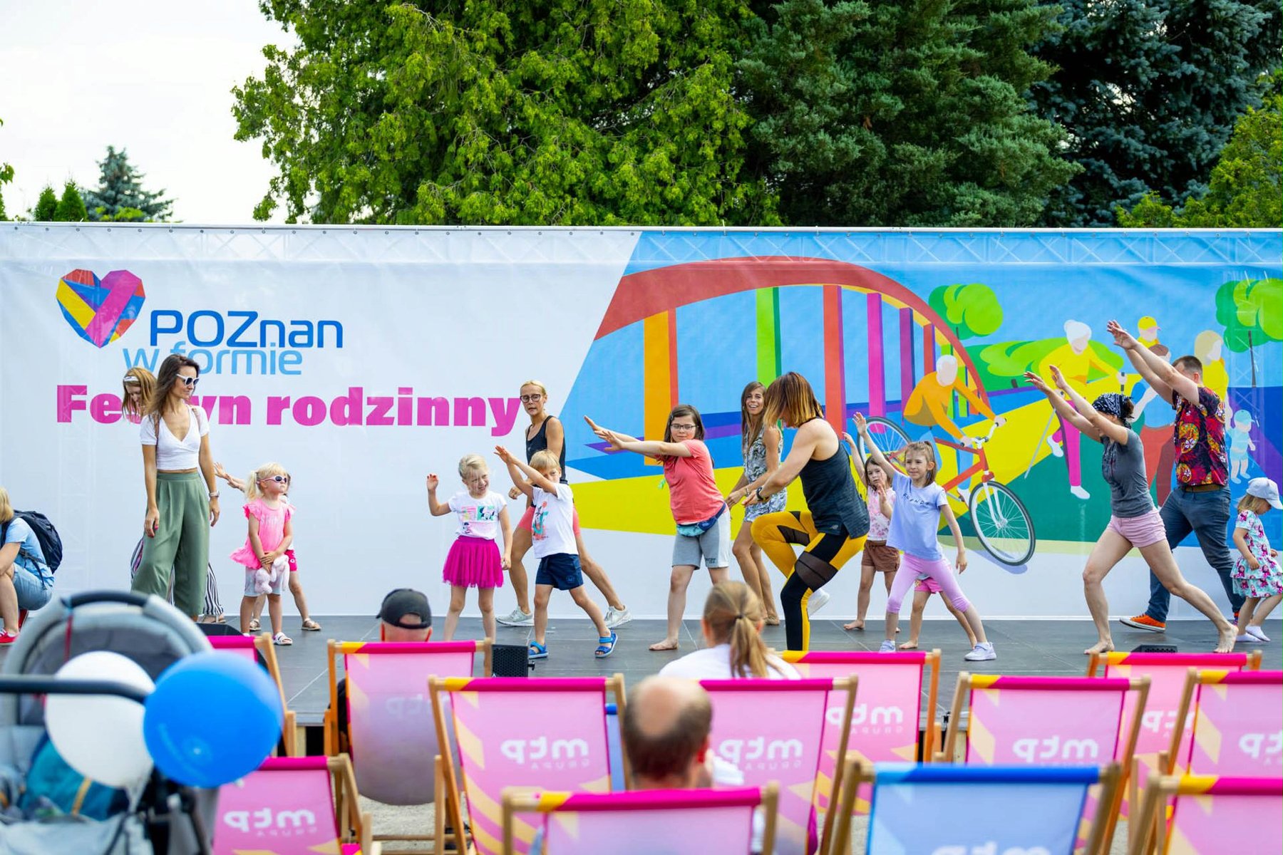 Na zdjęciu grupa dzieci bawiących się na scenie, w tle kolorowy baner z napisem: Poznań w formie - grafika artykułu