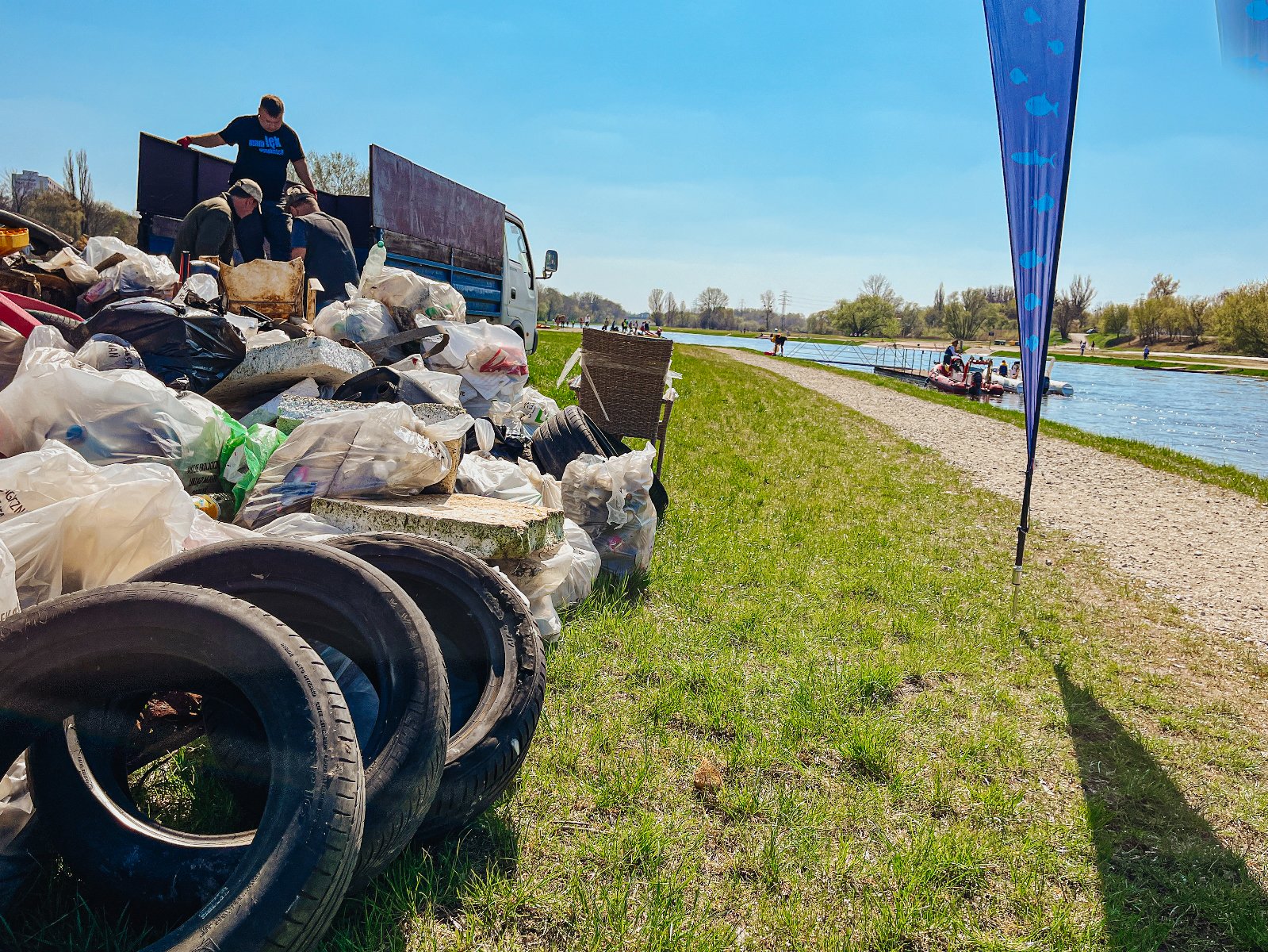 Na zdjęciu zebrane śmieci w workach leżące obok rzeki - grafika artykułu