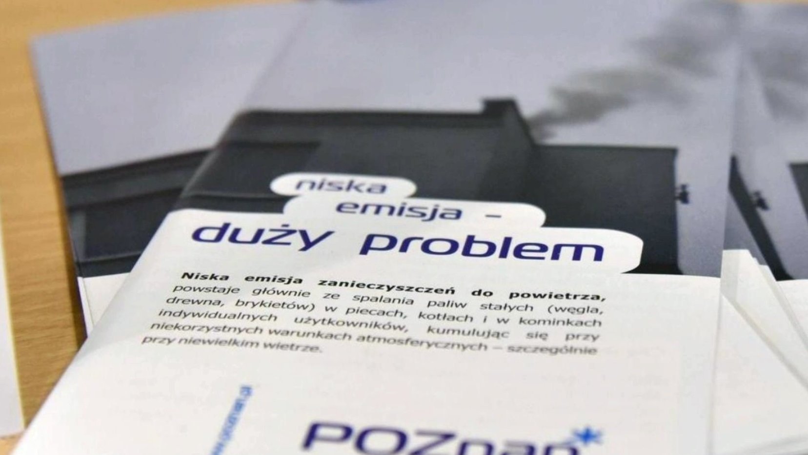 Na zdjęciu ulotki z napisem: niska emisja, duży problem