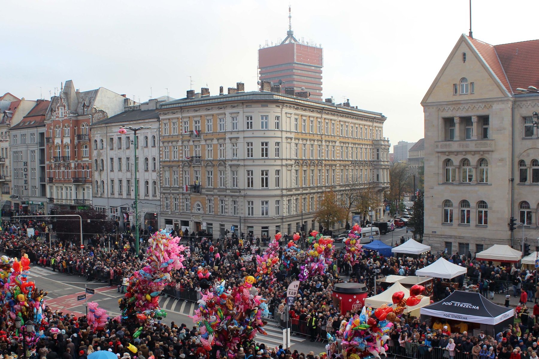 Zdjęcie przedstawia paradę świętomarcińską. Na ulicy widać tłum ludzi. W tle kamienice i budynek Uniwersytetu Ekominicznego. - grafika artykułu