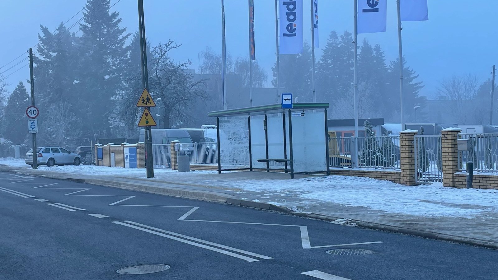 Zdjęcie przedstawia przystanek autobusowy pokryty śniegiem.