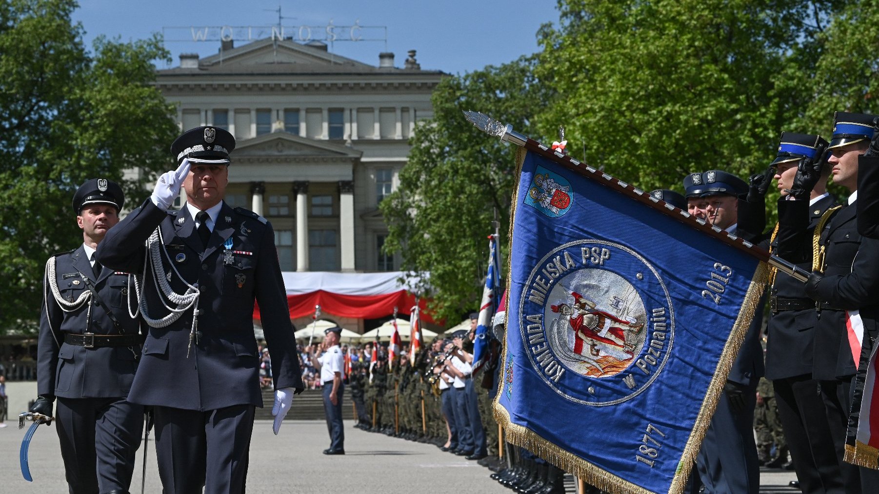 Na zdjęciu plac wolności, na nim mundurowi podczas meldunku