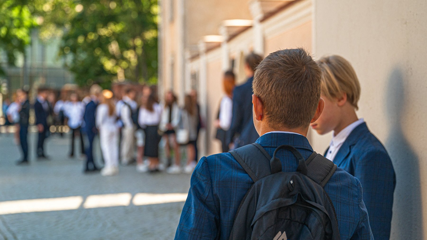 Zdjęcie przedstawia uczniów przed szkołą.