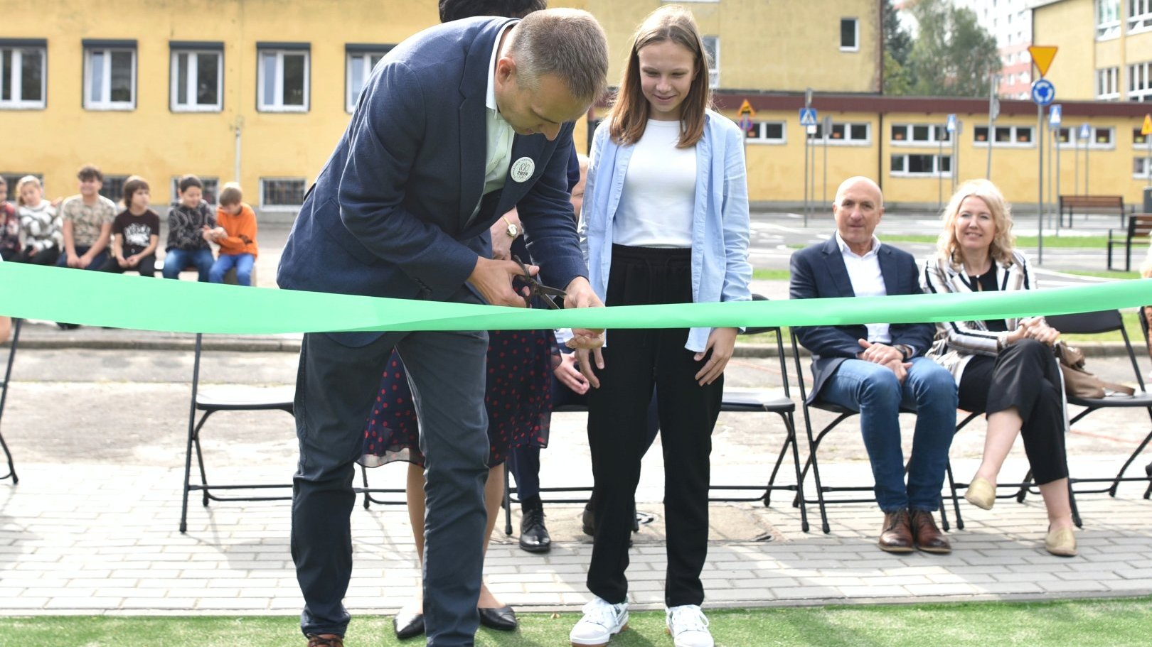 Zdjęcie przedstawia wiceprezydenta i uczennicę przecinających wstęgę.