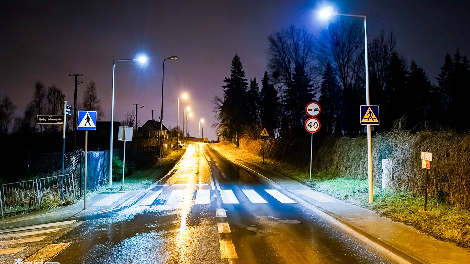 Na zdjęciu oświetlone przejście dla pieszych, w centrum pusta jezdnia