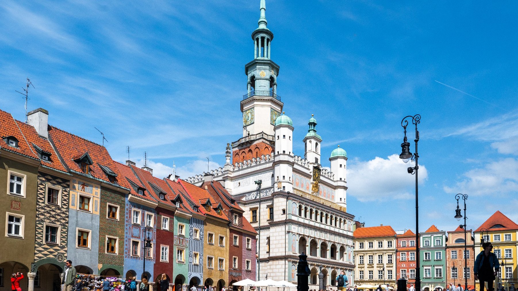 Zdjęcie przedstawia tłum ludzi na Starym Rynku. Widać na nim też ratusz, domki budnicze i inne kamienice.