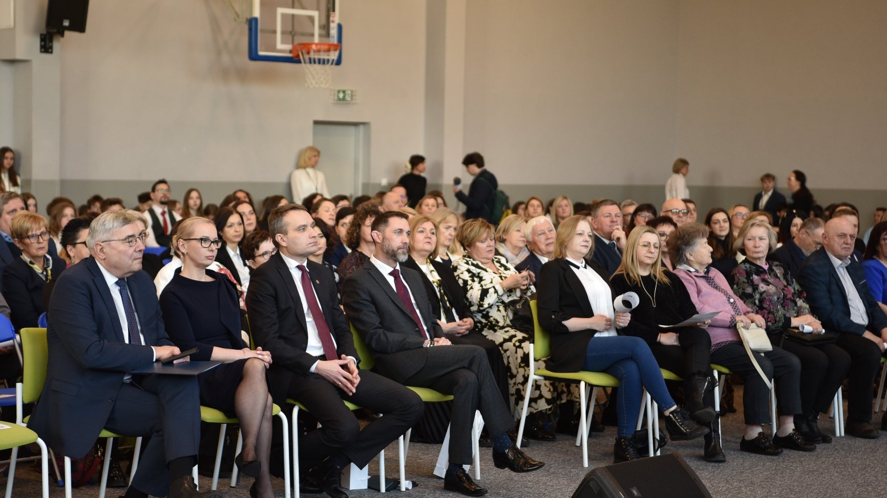 Zdjęcie przedstawia ludzi siedzących na widowni.