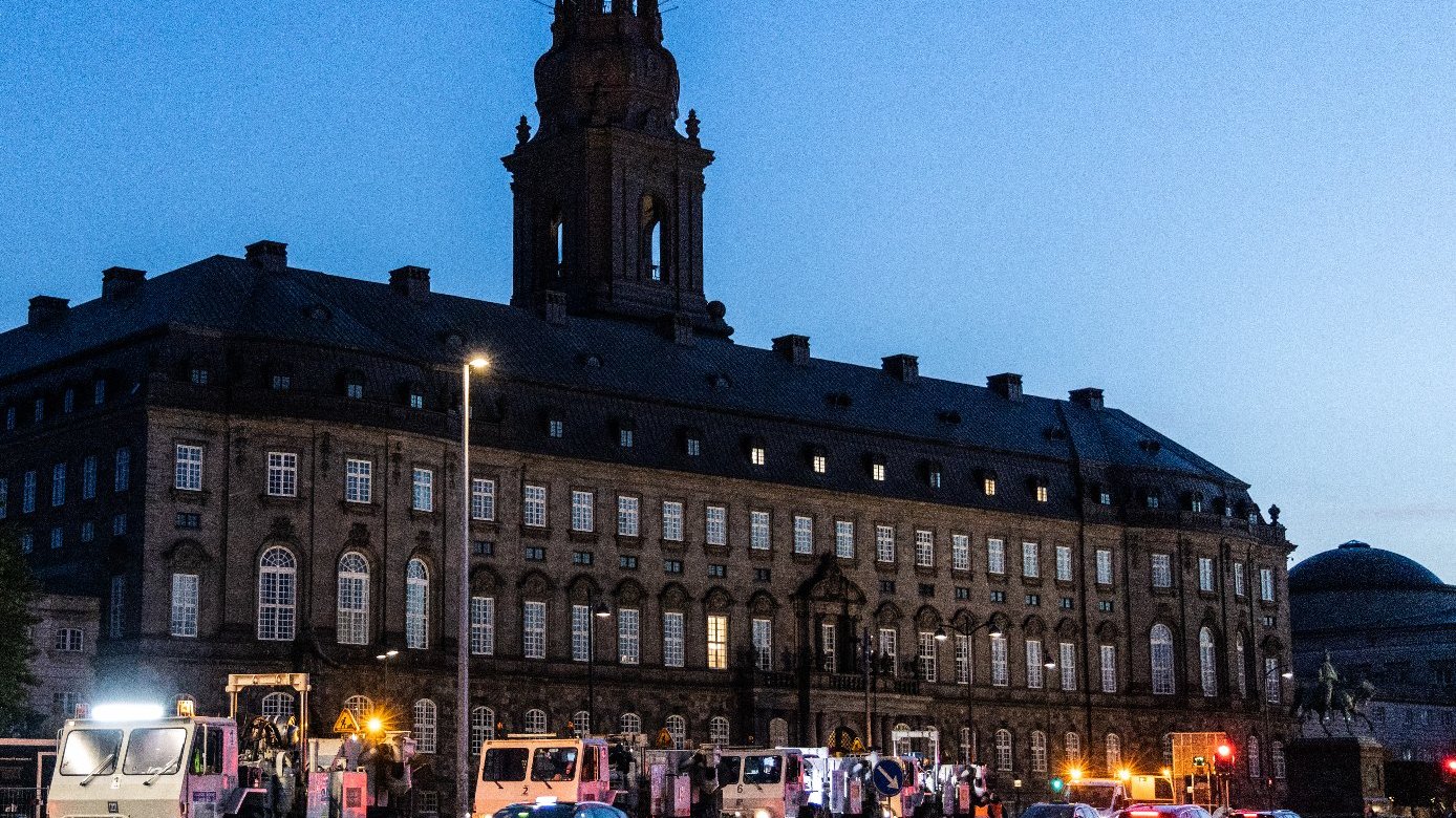 Zdjęcie przedstawia ciężarówki do pomiarów sejsmicznych jadące ulicą w nocy.