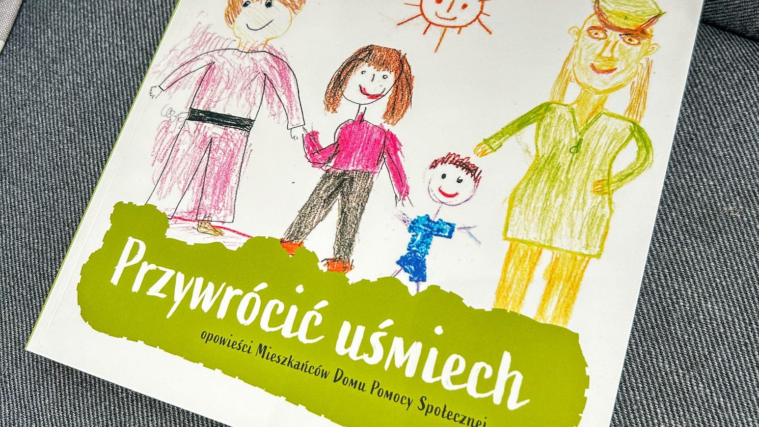 Na zdjęciu książka, na okładce tytuł - przywrócić uśmiech