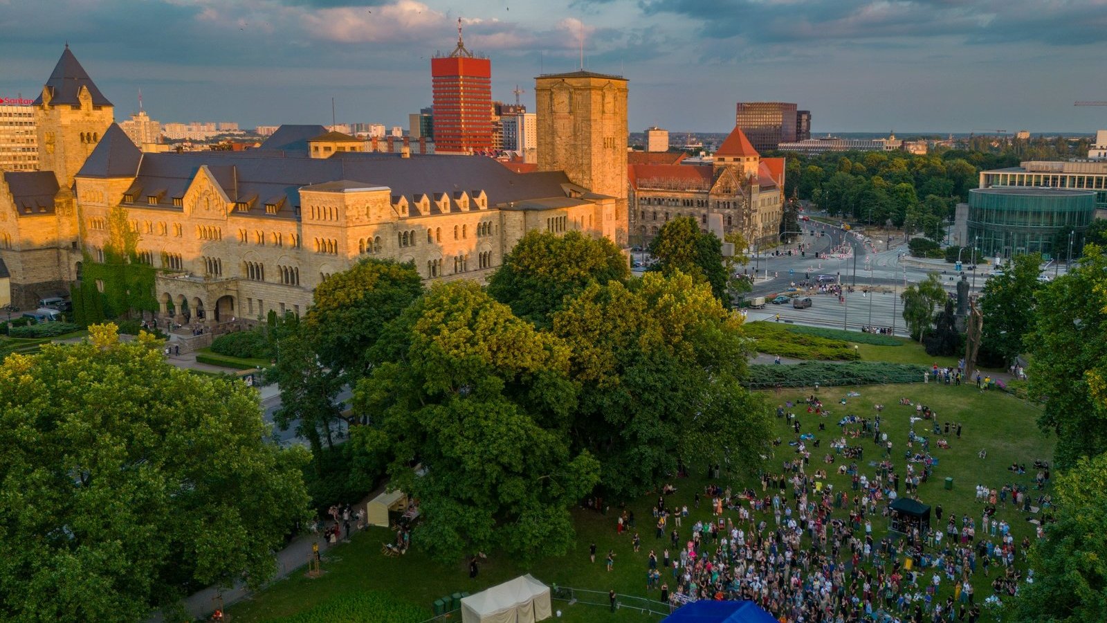 Zdjęcie przedstawia tłum ludzi w parku. Obok widać Centrum Kultury Zamek i inne budynki. Zdjęcie robione z góry.