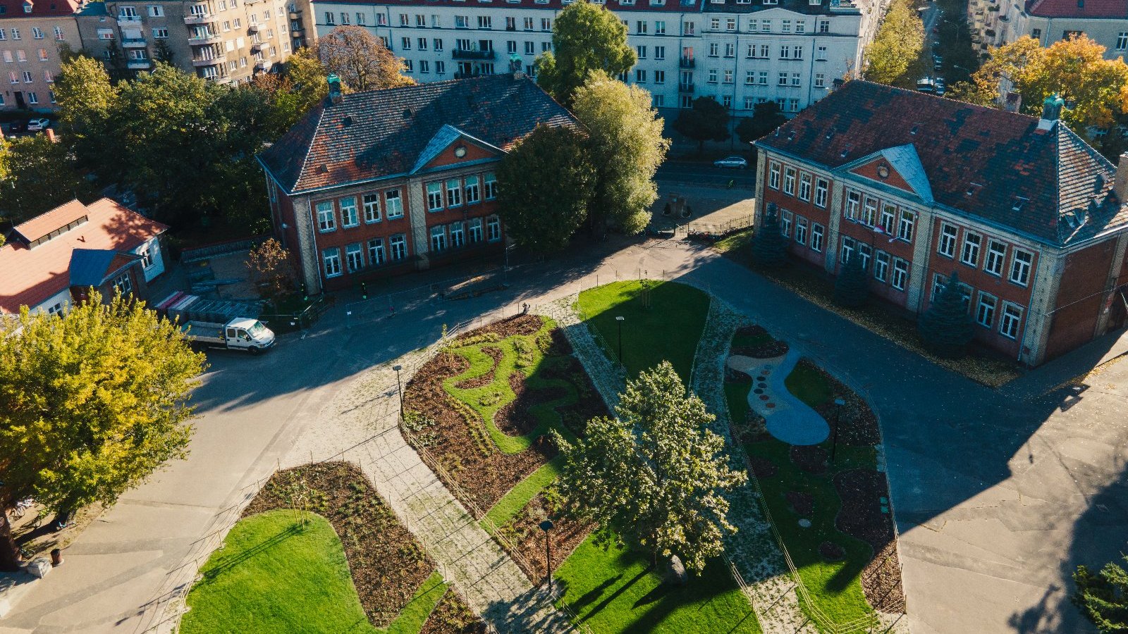 Widok z lotu ptaka na zmodernizowany, zielony dziedziniec szkoły.