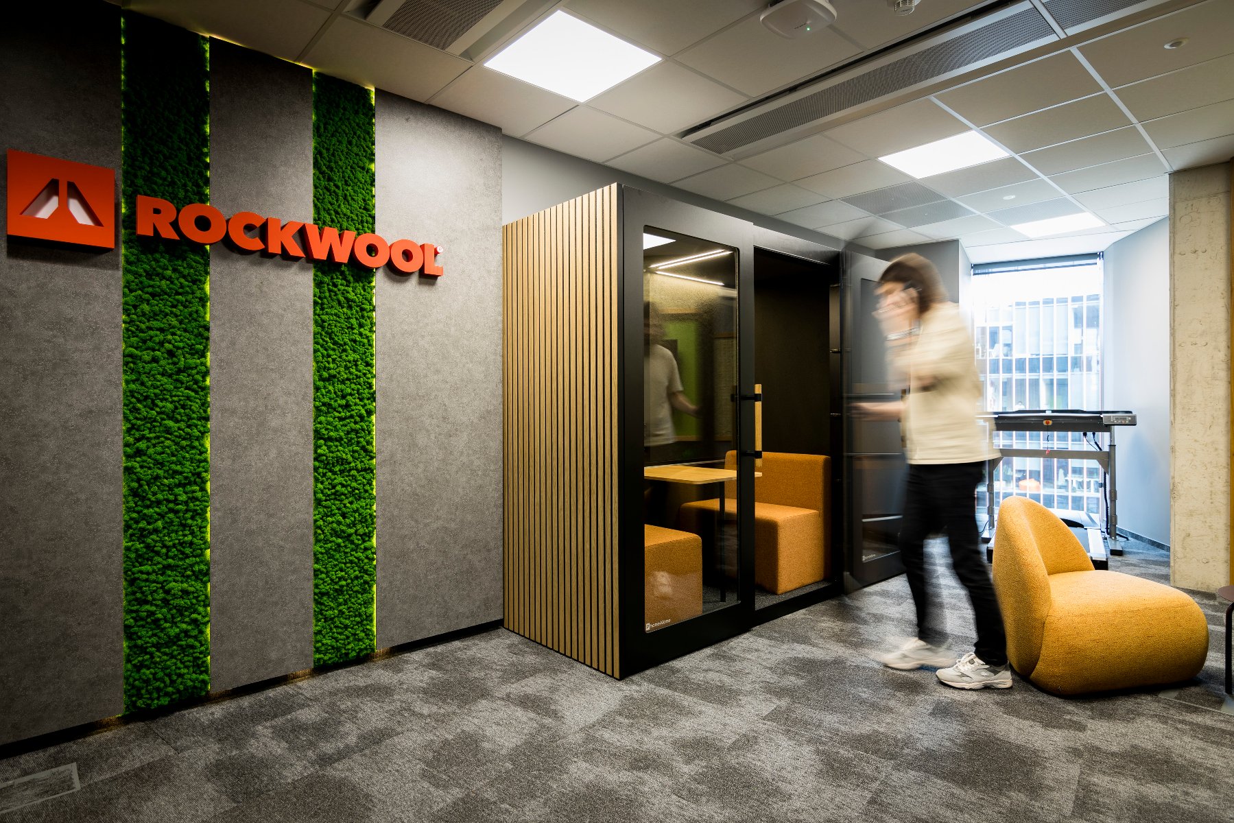 The Poznań branch of ROCKWOOL celebrates its 9th anniversary A quiet zone in the office corridor. The ROCKWOOL logo hangs on a wall with a green strip.
