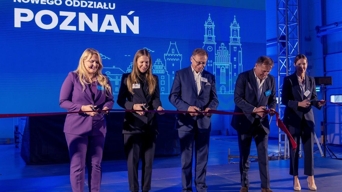 The photo shows representatives of SUUS Logistics, the mayor of Tarnów Podgórny and Head of the Investor Relations Department, Katja Lożina, during the grand opening of the company's warehouse. Individuals cut the red sash with scissors.