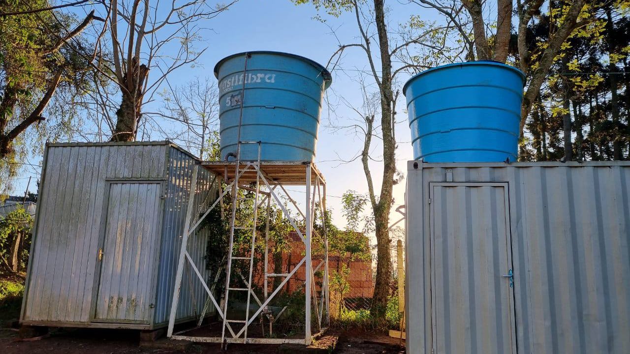 two meatal containers, between them a bucket with a ladder, on the right on the container itself a bucket