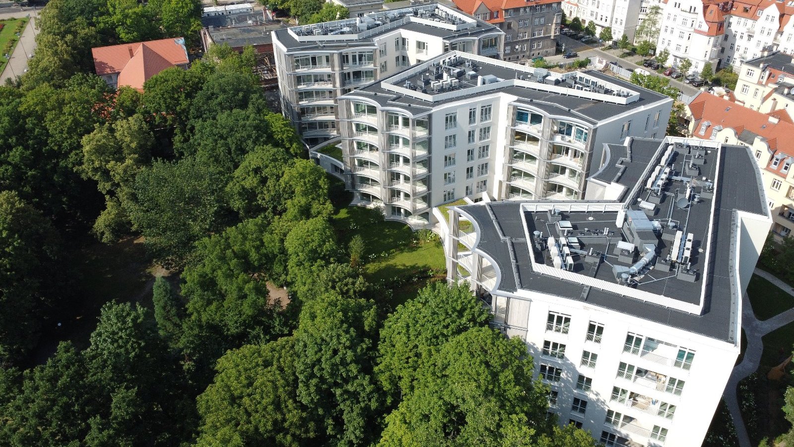 Bird's eye view photo of the Perfumiarnia development. In the distance, the urban development of Jeżyce, on the left, greenery can be seen.