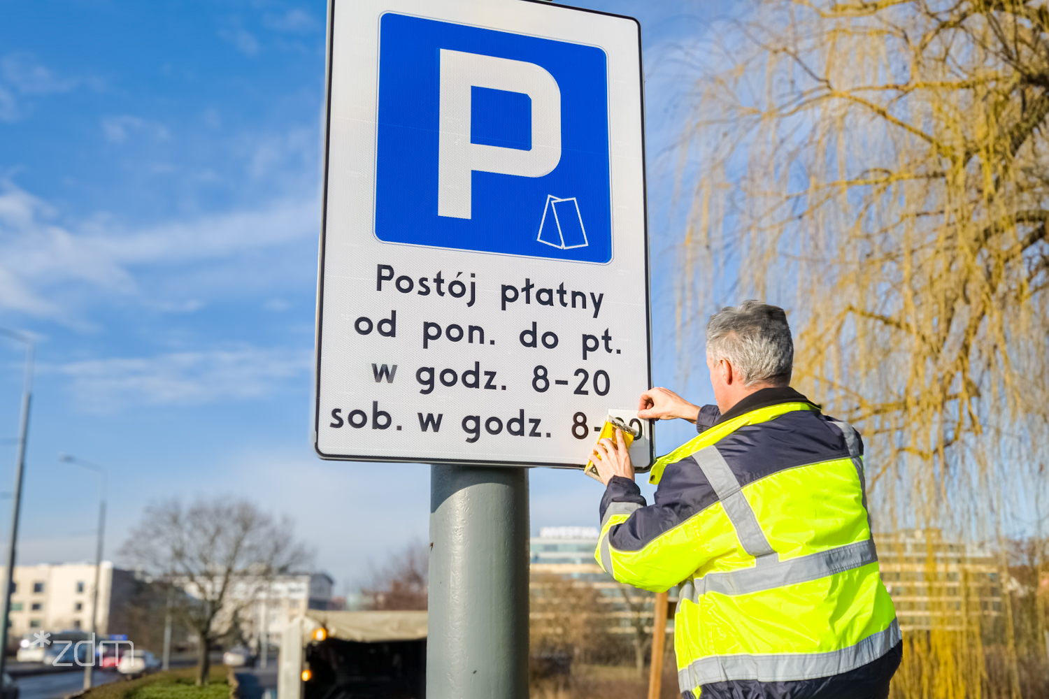 Zdjęcie osoby zmieniającej godzinę na znaku z literą P - grafika artykułu