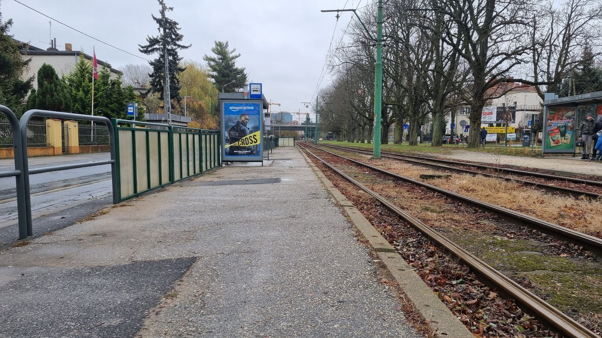 Przystanek przy torach tramwajowych przy ul. Klin, wiata przystankowa i barierki odgradzają przystanek od ulicy.