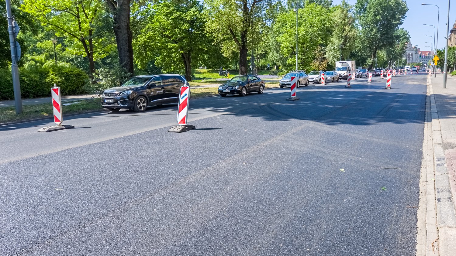 Aleja Niepodległości w trakcie remontu, biało czerwone pachołki wygradzają część jezdni