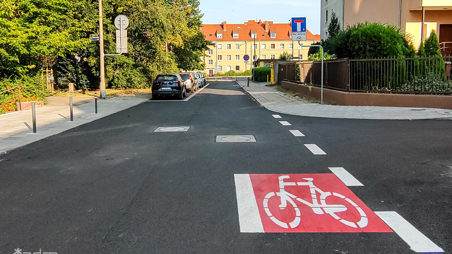 Ulica Engestrőma z nowym asfaltem, znakami poziomymi, miejscami postojowymi i chodnikiem oddzielonym słupkami