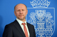 Profile picture of Third Deputy Mayor. Men wearing a black suit and red tie.