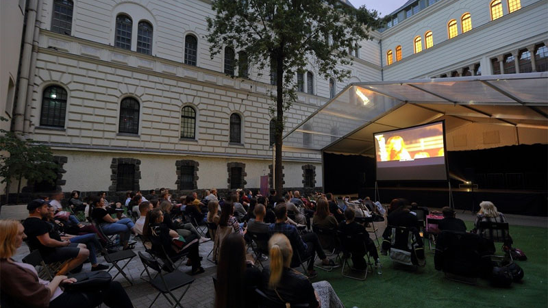 Dziedziniec Centrum Kultury Zamek. Na dziedzińcu widzowie na leżakach.