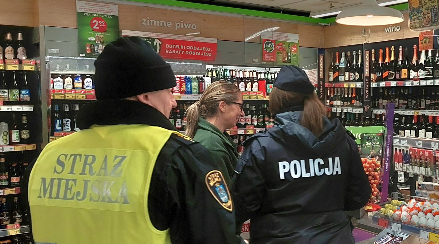 patrol profilaktyczny strażnik i policjantka w sklepie rozmawiają ze sprzedawczynią