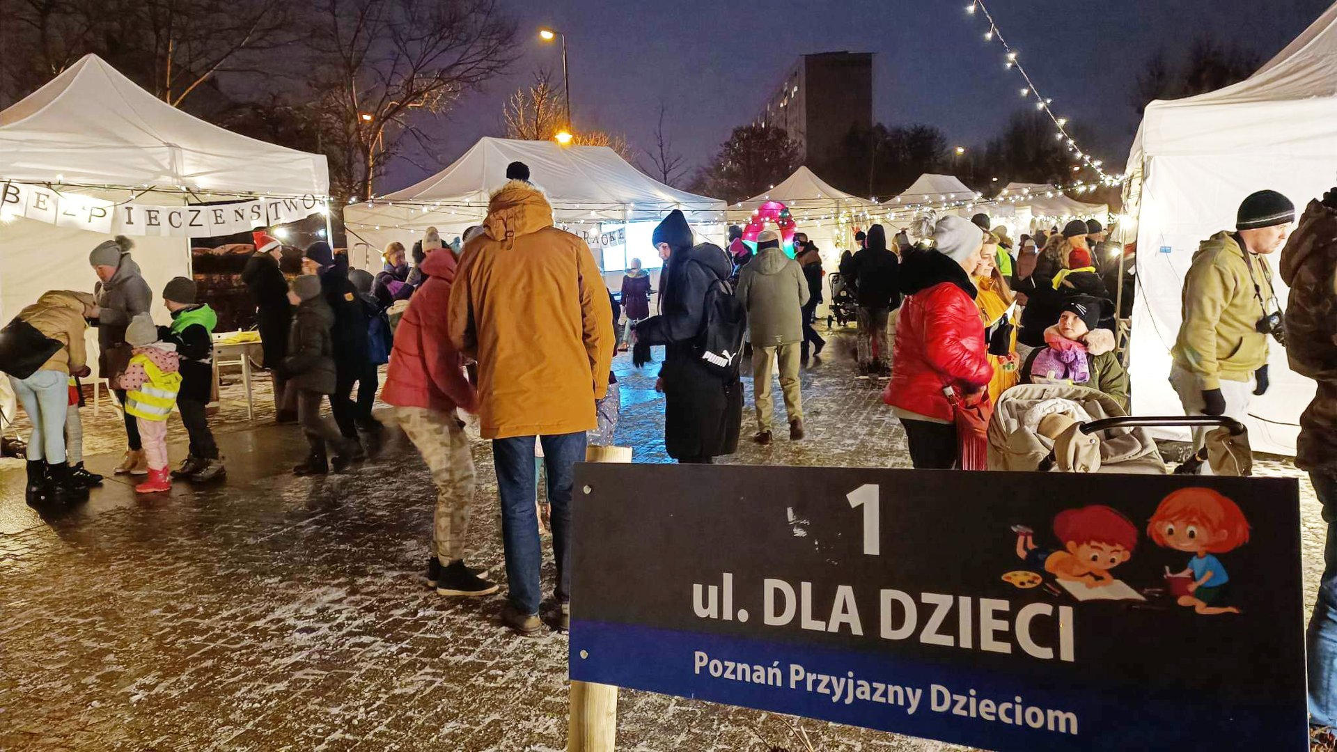 Na zdjęciu ulica dzieci - widać teren parku, ustawione namioty, pomiędzy nimi rodzice z dziećmi