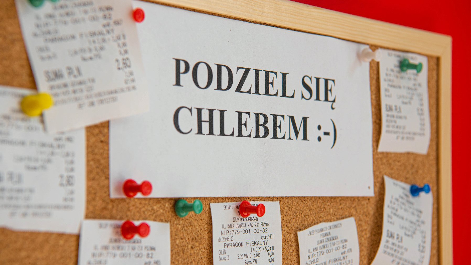 Na zdjęciu tablica z zawieszonymi parapetami i napisem: podziel się chlebem