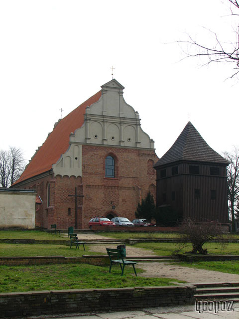 Kościół Świętego Wojciecha. Przed kościołem ławki i samochody.