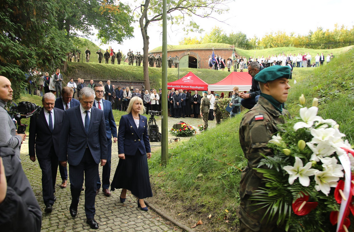 uroczystości w forcie siódmym, delegacja idzie złożyć kwiaty, przed nimi idzie żołnierz, w tle pozostali uczestnicy - grafika artykułu