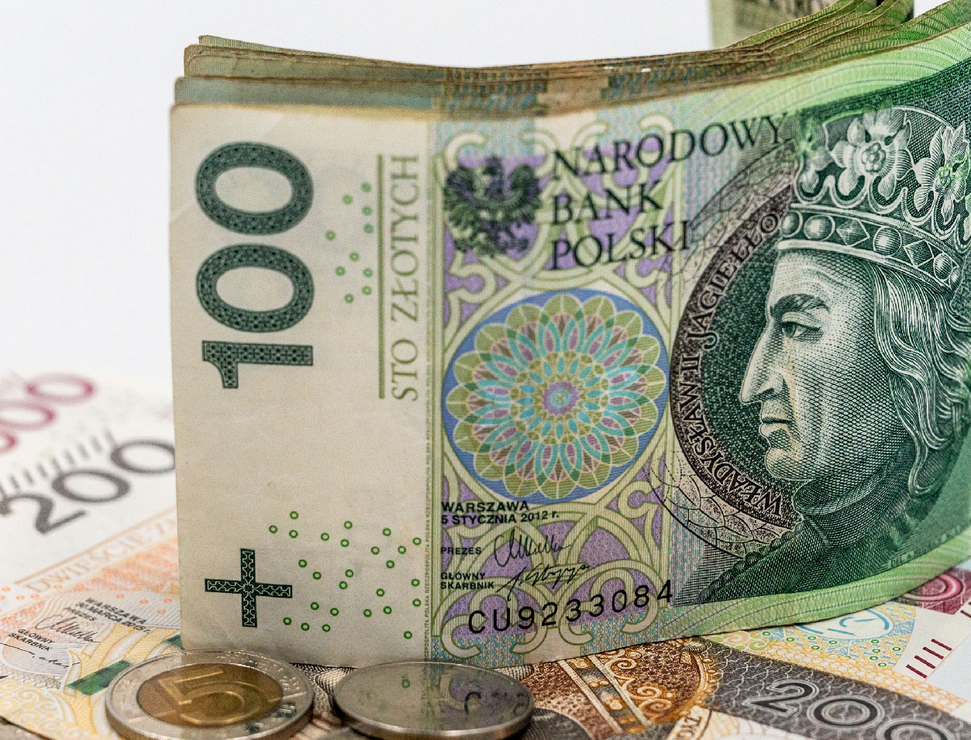 banknot 100 zł, pod nim banknoty 200 zł, obok monety, jedna z nominałem 5 zł, grafika artykułu - grafika artykułu