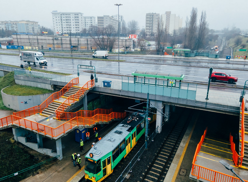 wiadukt z jezdnią nad torami tramwajowymi, z wiaduktu prowadzą schody na przystanej, na jezdni samochody, pod wiaduktem tramwaj - grafika artykułu