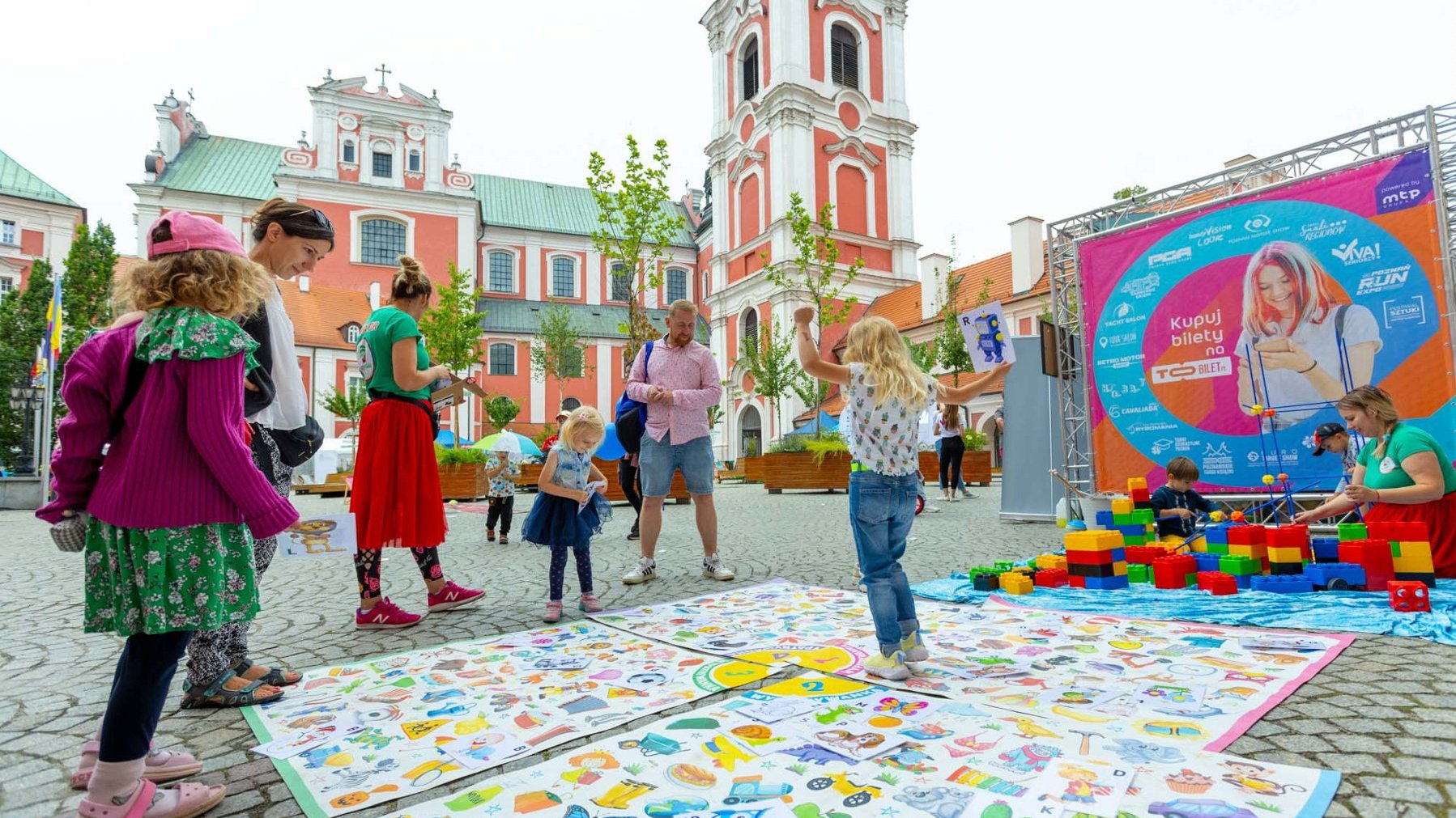 Na zdjęciu dzieci oraz dorośli przy grze rozłożonej na wolnym dziedzińcu urzędu miasta