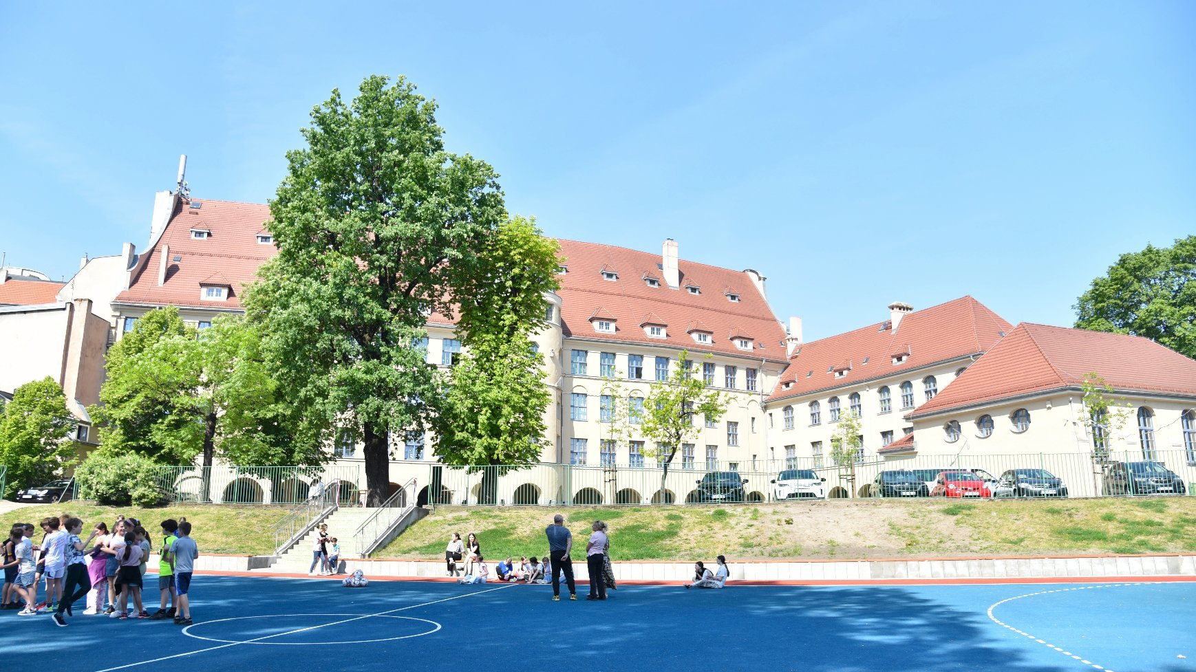 Zdjęcie przedstawia boisko i budynek szkoły.