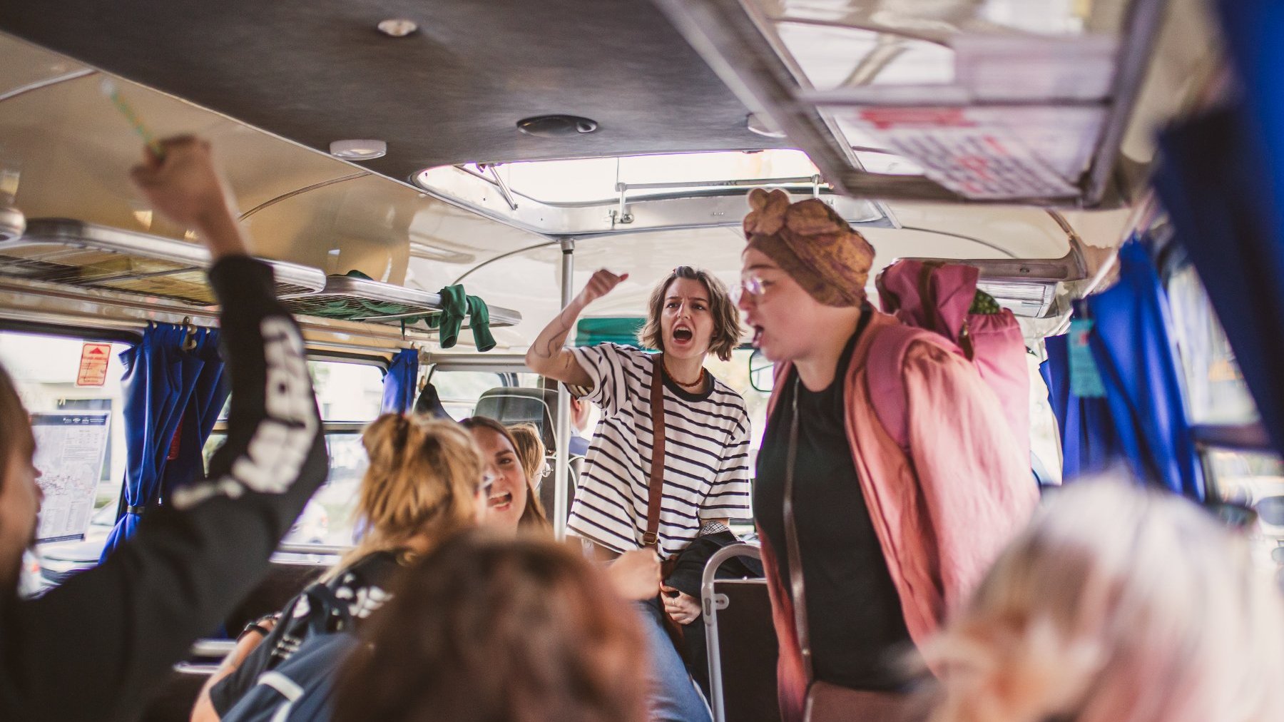 Zdjęcie przedstawia ludzi w autobusie.