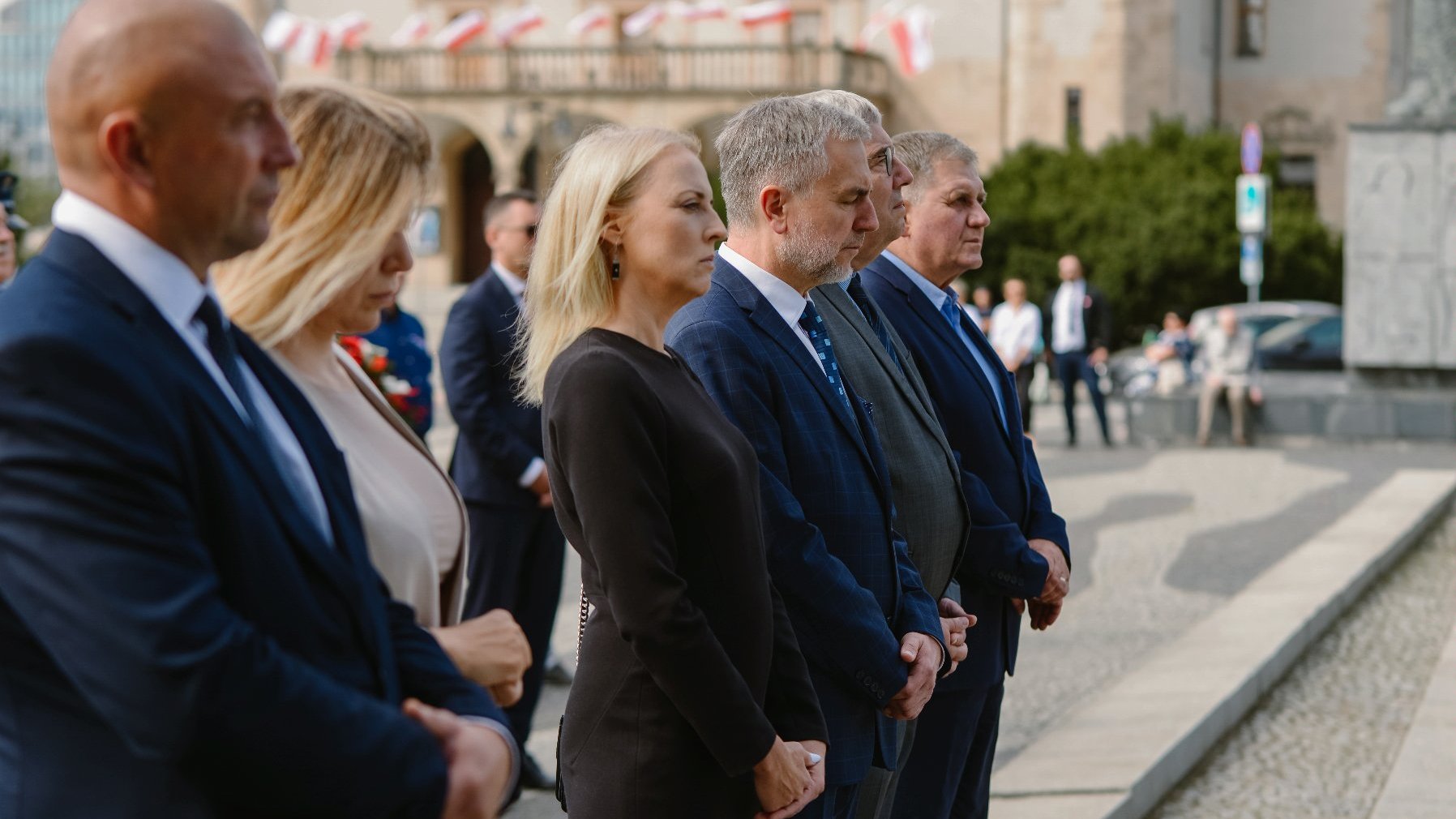 Zdjęcie przedstawia ludzi stojących na placu Mickiewicza.