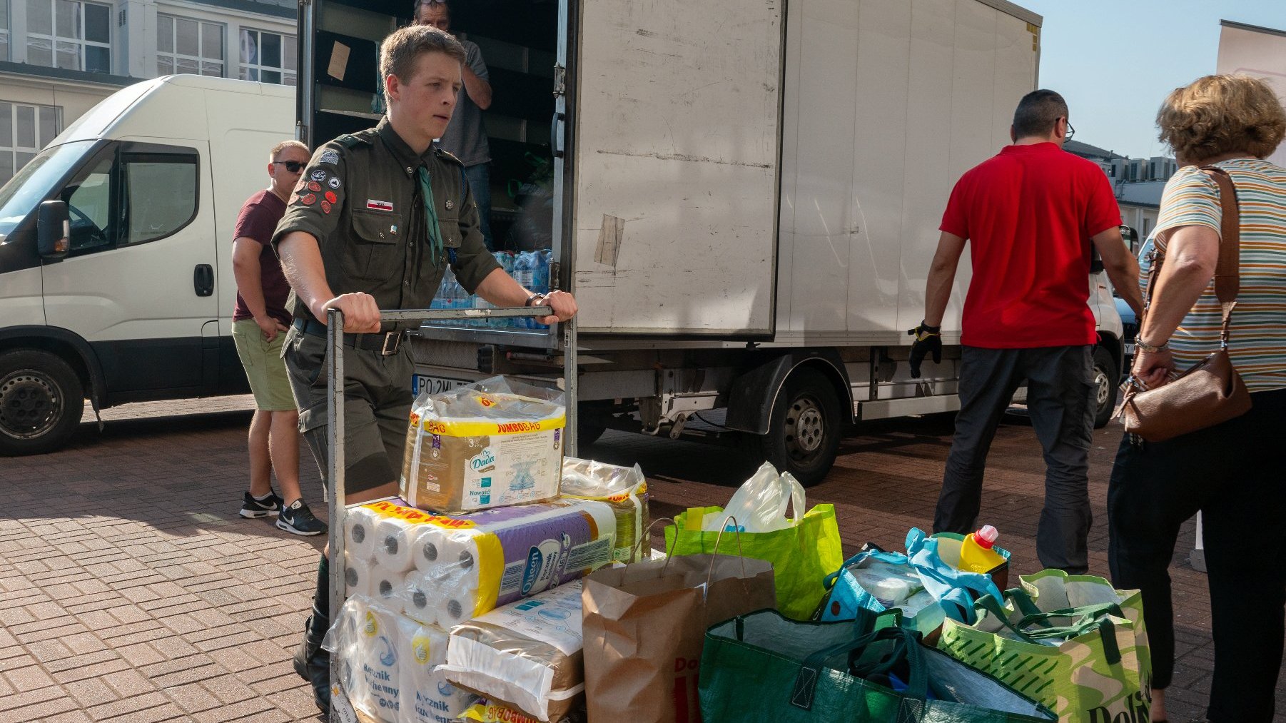 Na zdjęciu harcerz pcha wózek z darami