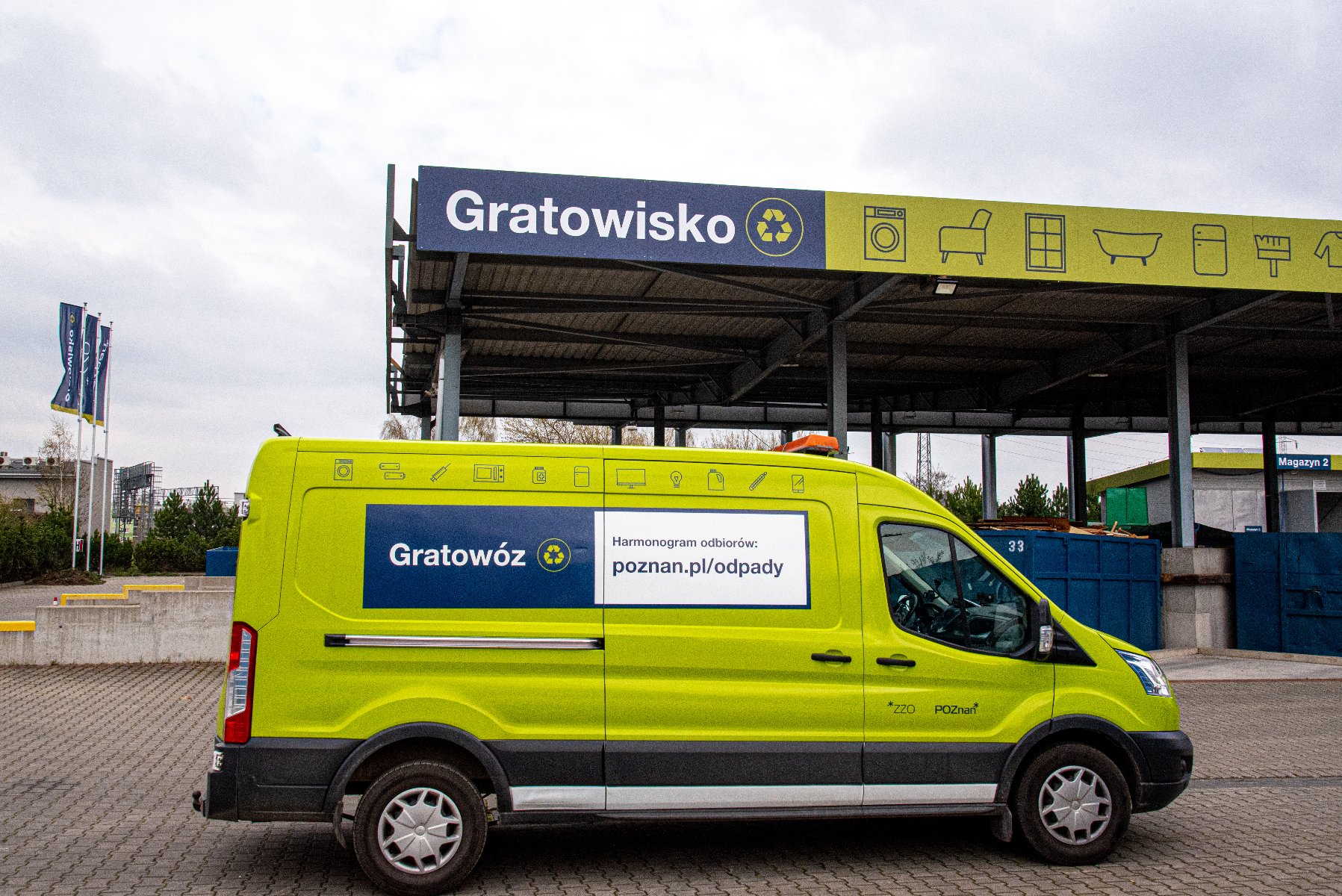 Zielony samochód dostawczy z napisem "Gratowóz" na tle obiektu z napisem "Gratowisko" i ikonami przedstawiającymi przedmioty gospodarstwa domowego: pralkę, krzesło, wannę i lodówkę. Obiekt i pojazd są częścią systemu gospodarowania odpadami w Poznaniu. - grafika artykułu