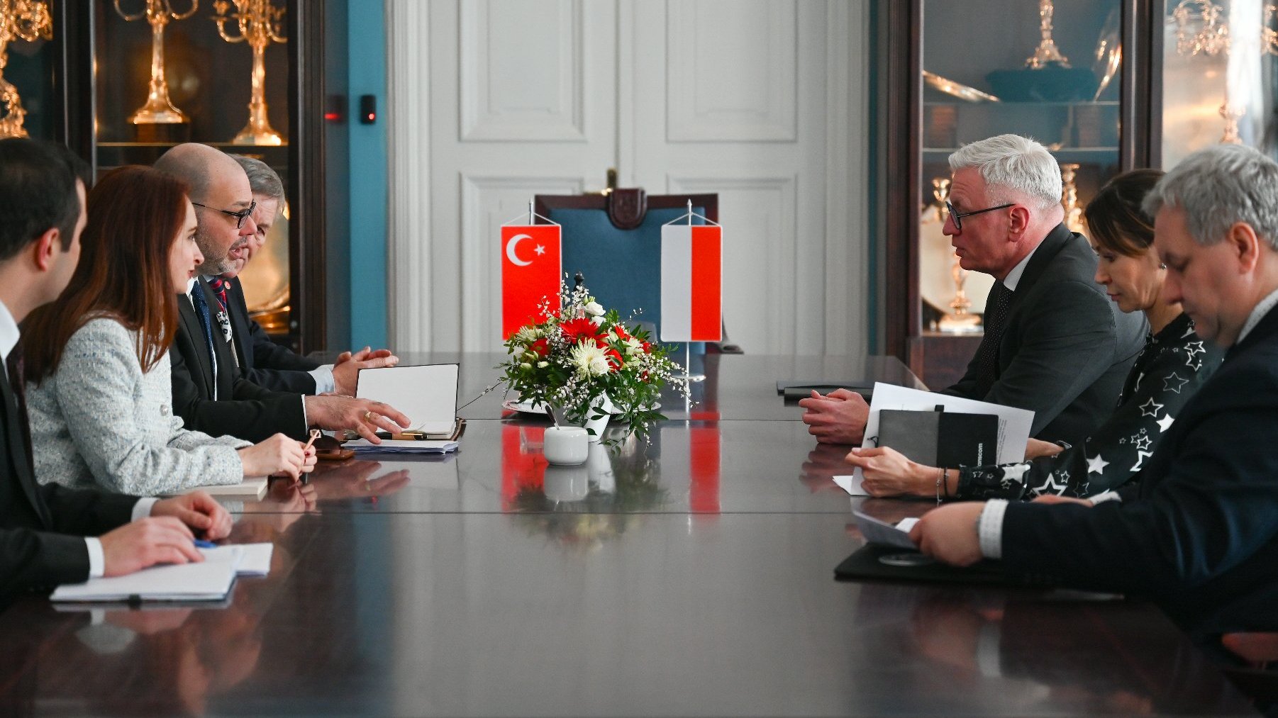 Na zdjęciu ludzie siedzący za stołem, na nim flagi Turcji i Polski