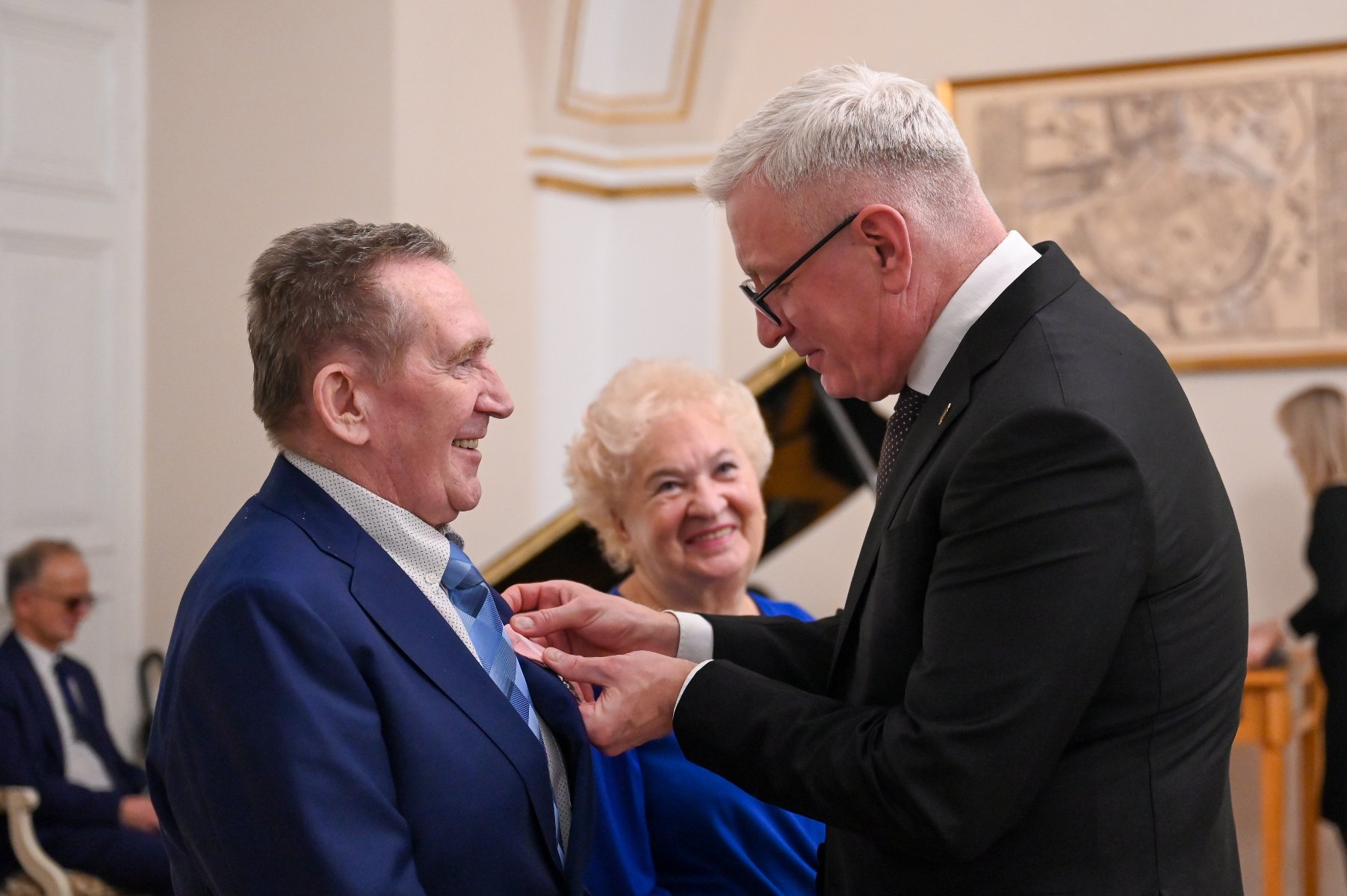 Na zdjęciu Jacek Jaśkowiak, prezydent Poznania, przypinający medal mężćzyźnie - grafika artykułu