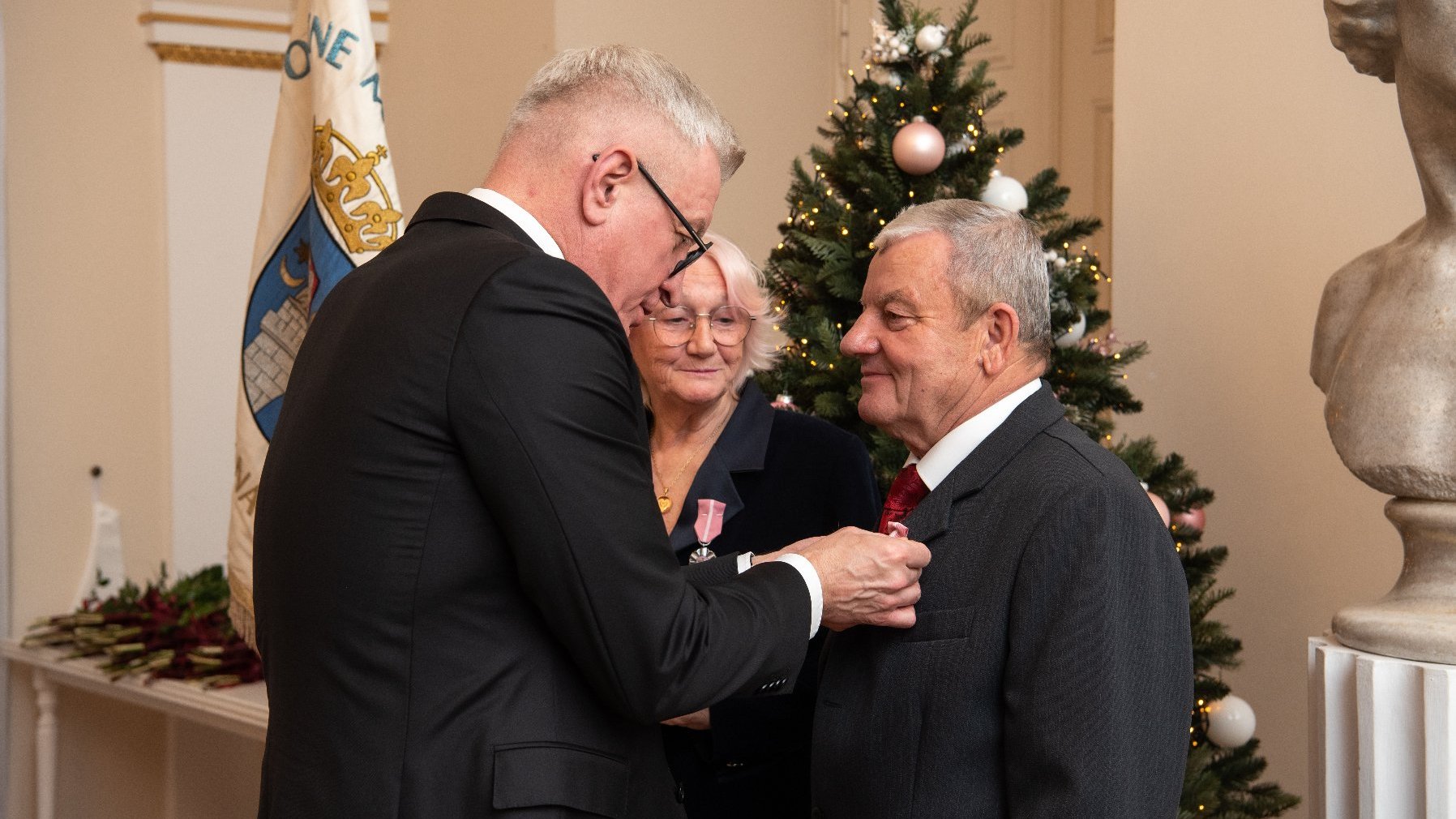 Na zdjęciu prezydent Poznania przypinający medal mężczyźnie