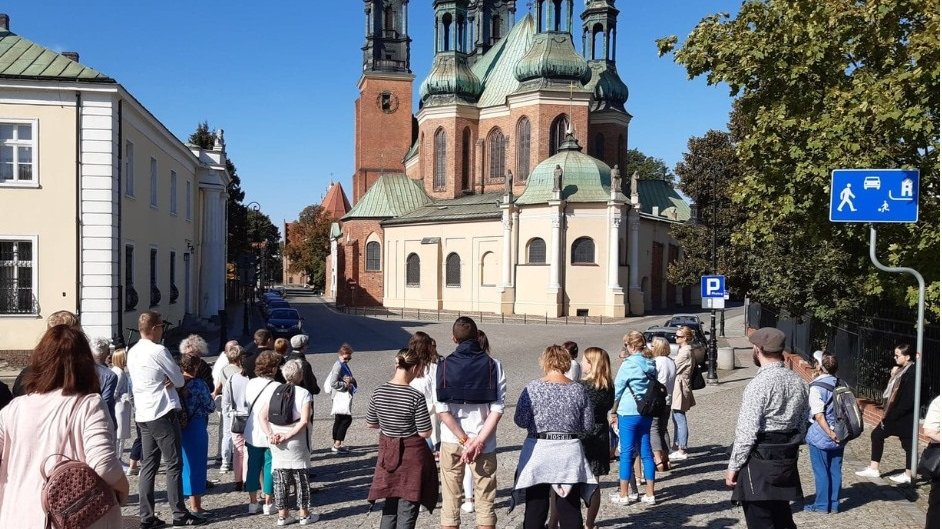 Grupa uczestników przechadzki przed kościołem, będącym jednym z punktów zwiedzania.