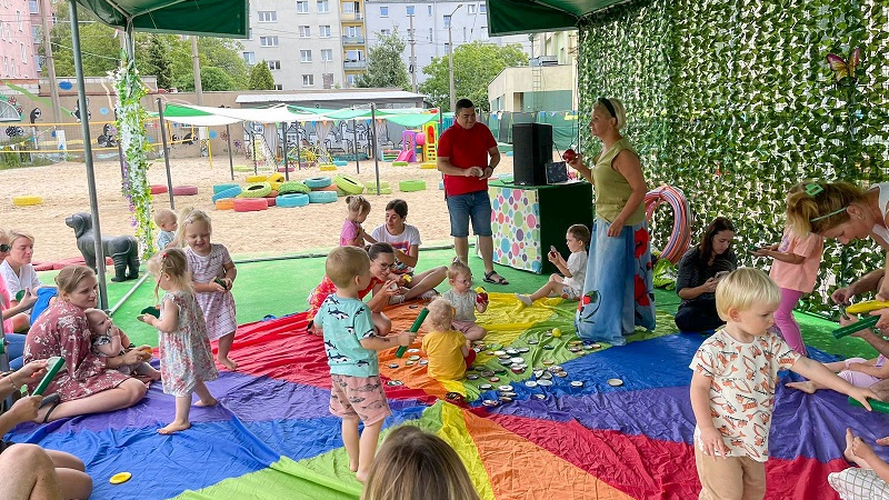 Małe dzieci bawiące się na kolorowej planszy.