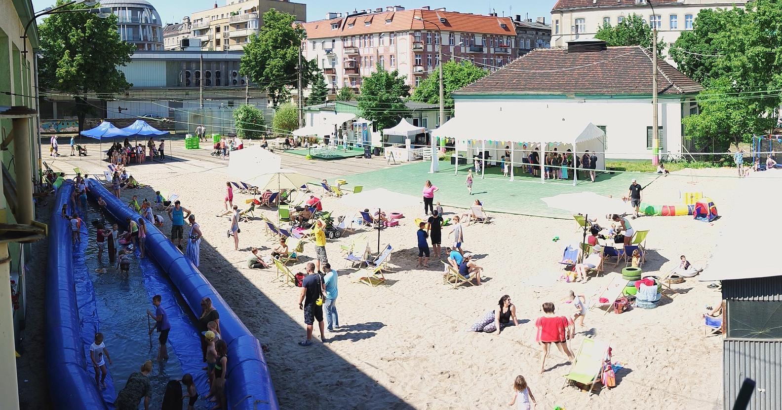 Widoczny jest plac nieczynnej zajezdni przy ulicy Madalińskiego, na którym latem bawią się dzieci podczas warsztatów wakacyjnych organizowanych przez Urząd Miasta w Poznaniu. - grafika artykułu